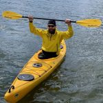 Гребець сидить у жовтому каяку SeaBird Expedition Åfjord Pro на воді