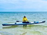 Гребець стоїть у морі та тримає спортивний каяк SeaBird Sport 600